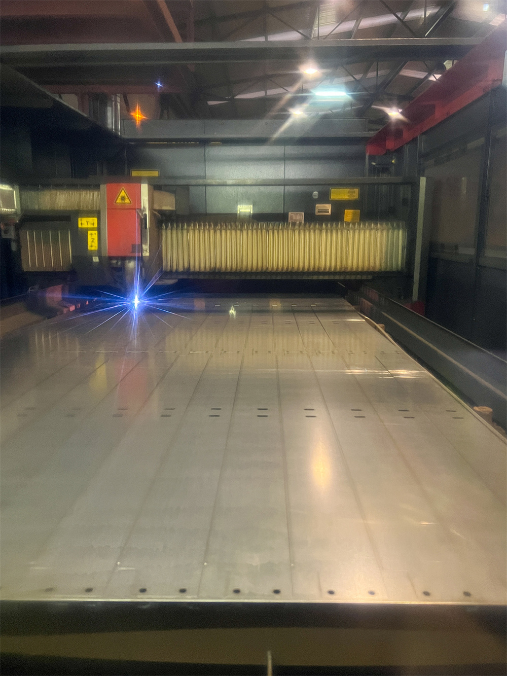 Close up of a laser cutting head working on metal sheet