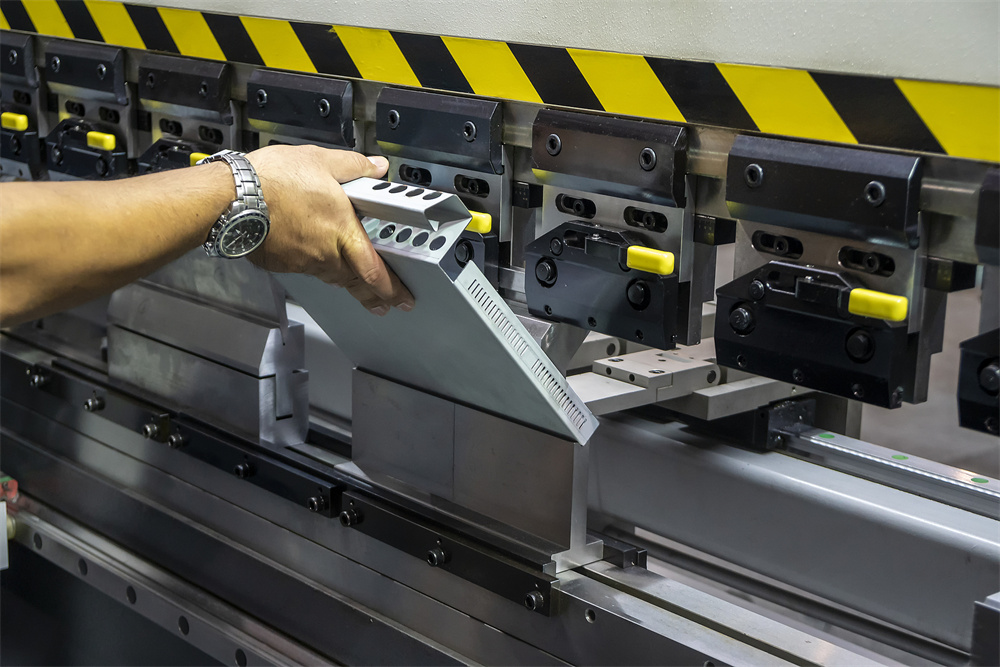 Technician adjusting a hydraulic press brake backgauge