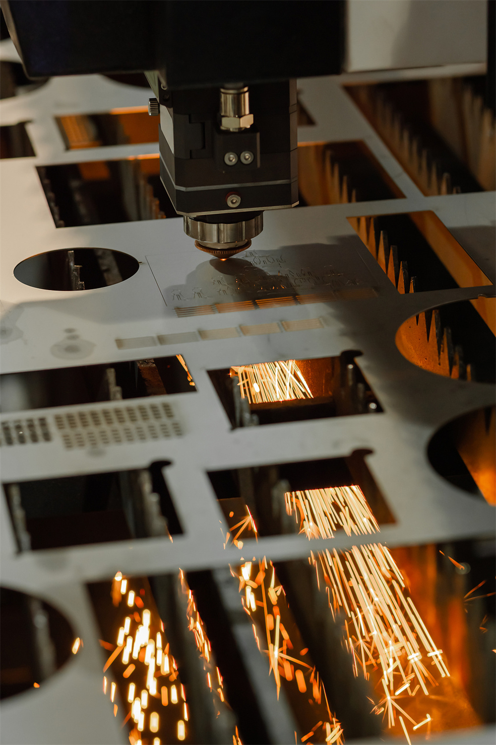 Laser cutting machine working on sheet metal with sparks